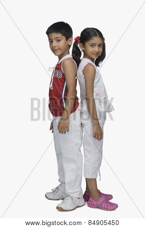 Portrait of two children standing back to back
