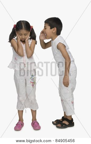 Girl covering her ears while her brother shouting
