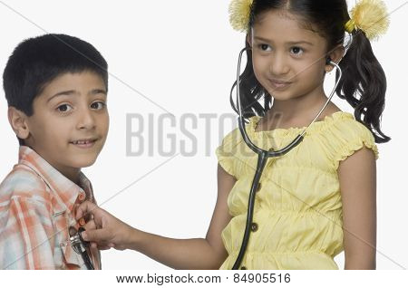 Girl examining a boy with a stethoscope