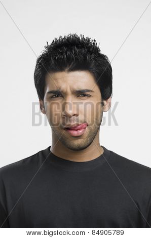Man sticking his tongue out and thinking