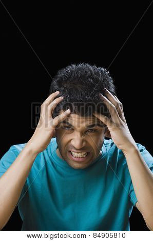 Close-up of a frustrated man holding his head