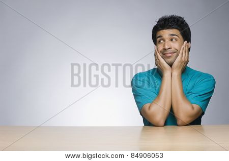 Man looking sideways with his head in his hands