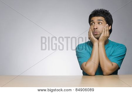 Man puckering with his head in his hands