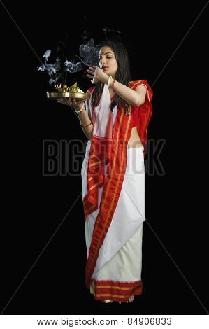 Beautiful woman in a Bengali sari holding pooja thali