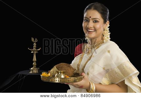 A South Indian woman holding a plate of religious offerings
