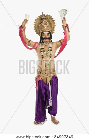 Man dressed-up as Ravana holding Indian paper currency
