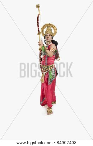 Man dressed-up as Rama and holding a bow and arrow