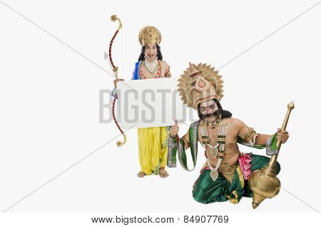 Men dressed-up as Rama and Ravana and holding a blank placard