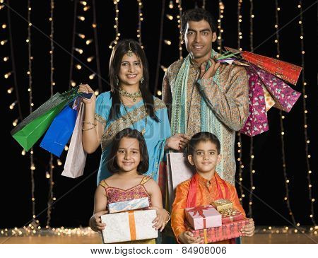 Family carrying shopping bags and gifts for Diwali