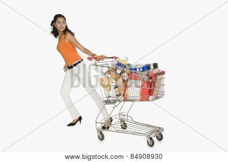 Woman pulling a shopping cart and smiling