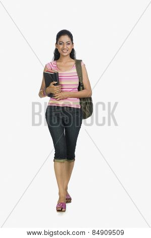 University student carrying a bag and books