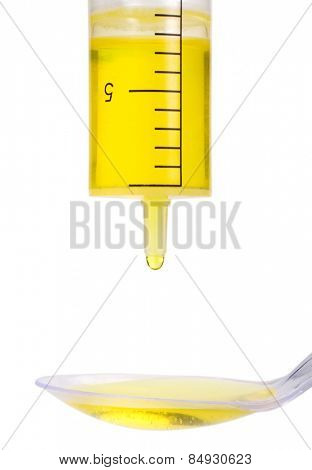 Medicine dropping out from a doser onto a spoon