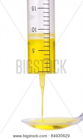 Medicine dropping out from a doser onto a spoon