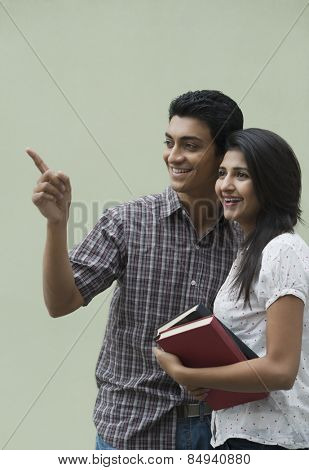 College students holding books and smiling