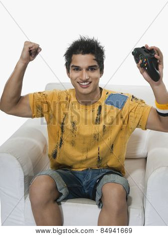 Portrait of a man cheering while playing video game