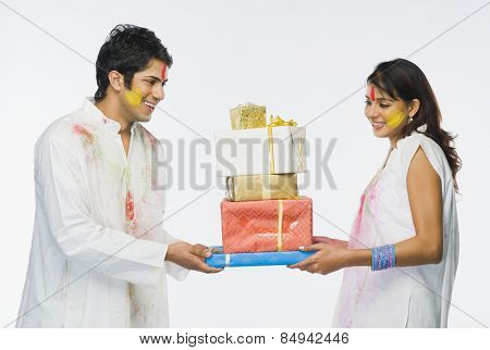 Couple holding Holi gifts