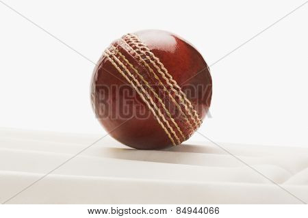 Close-up of a cricket ball on a cricket pad