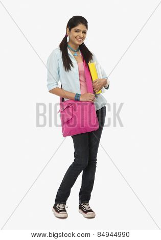 Female university student holding books and smiling