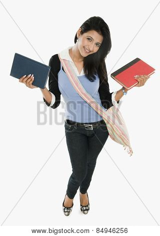 University student holding books and smiling