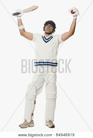Cricket batsman holding a ball and bat with his arms raised