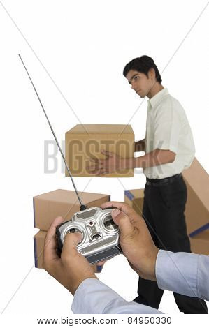 Person's hands controlling worker with remote control