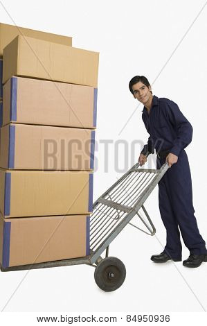 Storekeeper carrying cardboard boxes on a hand truck