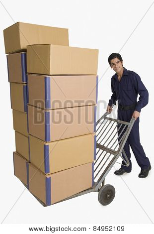Storekeeper carrying cardboard boxes on a hand truck
