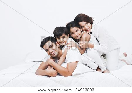 Portrait of a happy family on the bed