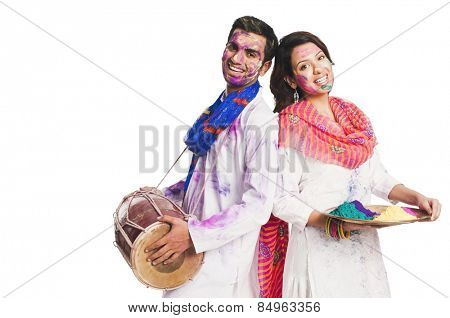 Couple celebrating Holi with colors and a drum