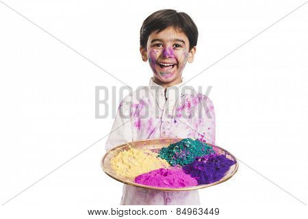 Boy holding Holi colors in a plate