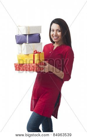 Portrait of a happy woman holding a stack of gifts