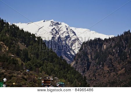 Town with snow covered mountains in the background, Manali, Himachal Pradesh, India