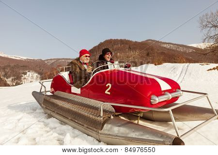 Elderly couple on a pedalo in the snow