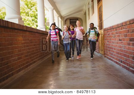 Full length portrait of school kids running in school corridor