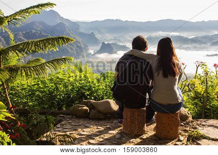 man and woman see the landscape of misty mountains Phu Langka National Park.