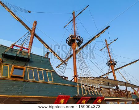 Masts of the ancient sailing ship on the blue sky background