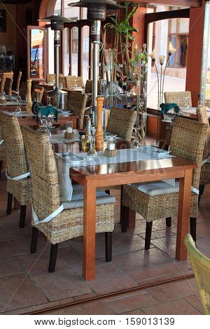 Wicker chairs and table in empty comfortable restaurant