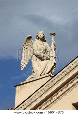 Angel statue with candelabra on top of Saint Rocco church in Rome Italy