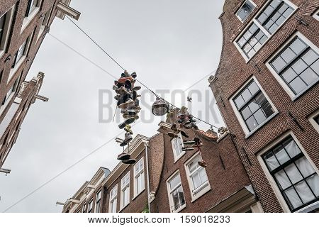 Hanging shoes in a street in historical city center of Amsterdam. It is one of the most romantic and beautiful cities in Europe. Amsterdam is also a city of tolerance and diversity.