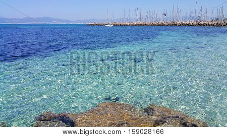 Beautiful sea views with transparent turquoise water yachts and Palma de Mallorca on the horizon. L'Arenal Majorca Balearic Islands Spain.