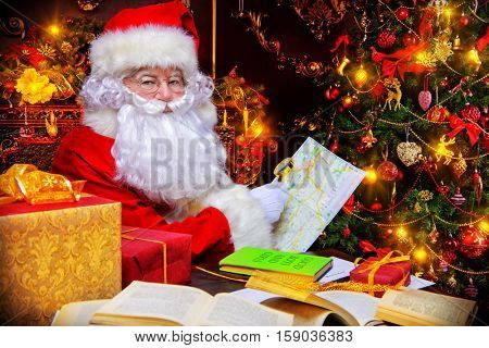 Christmas, mail of Santa Claus. Santa Claus at his home beautifully decorated for Christmas reading letters and making plans of travelling around the planet. Christmas time. Time for miracles.