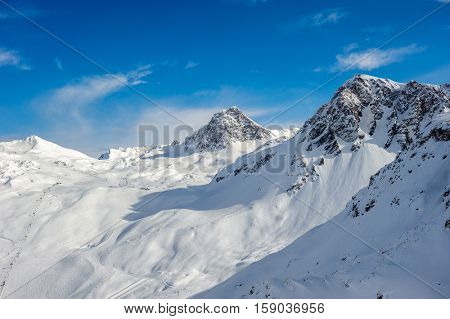 Alpine winter mountain landscape. French Alps covered with snow in sunny day. Val-d'Isere, France