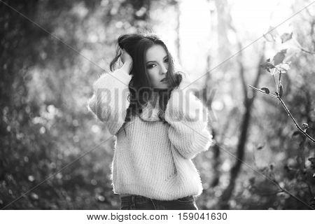 Young sexy thoughtful woman with long hair in fluffy sweater, black and white.
