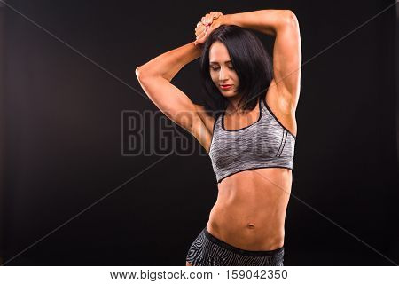 Fitness and sports body concept. Picture of brunette woman with red lips training while posing for photographer isolated on black background in studio.
