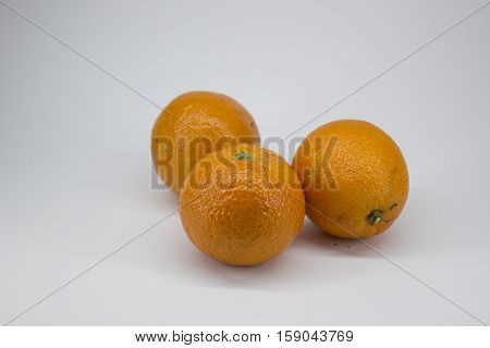 Three ripe tangerines on a white background