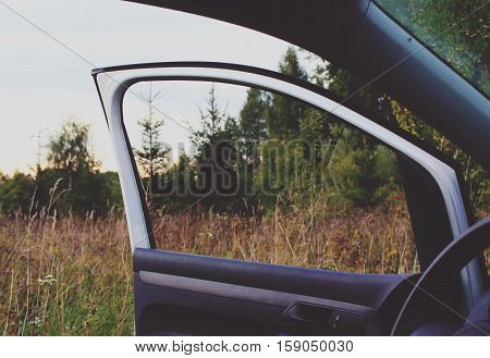 Modern car with opened door outdoors on nature background