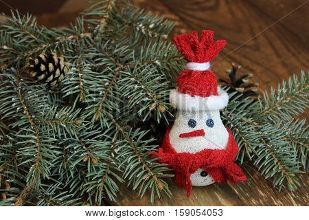 Snowman made from light bulb near Christmas tree