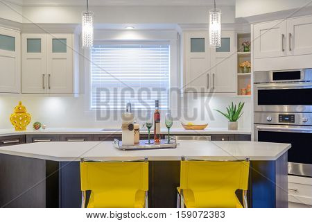 Modern, bright, clean, kitchen interior with stainless steel appliances in a luxury house