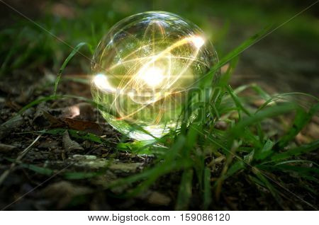 Magic crystal ball atom on forest floor for summer fantasy imagery