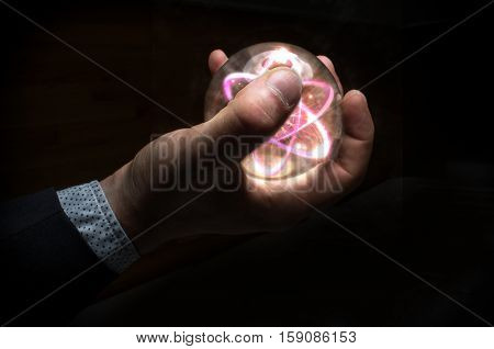 Holding atom in fortune teller magic crystal ball